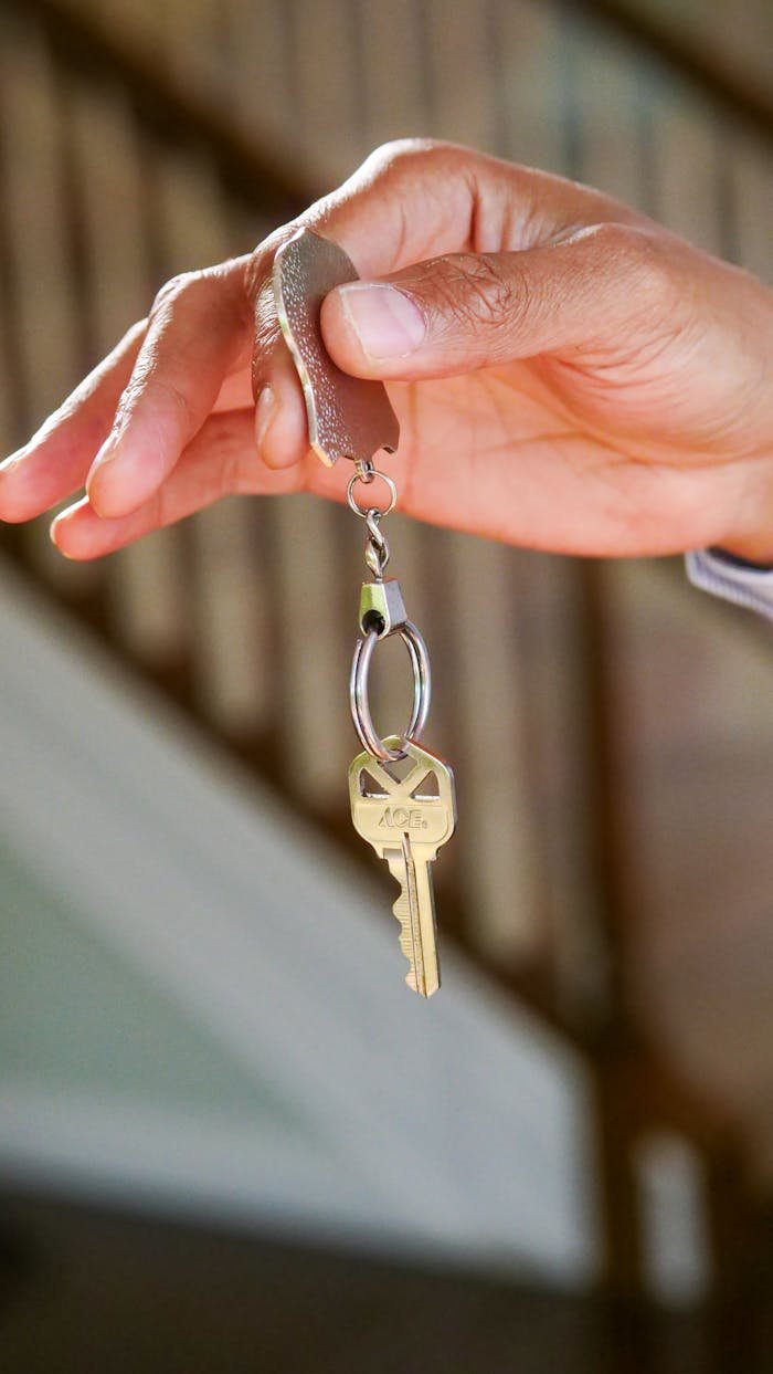 Person Holding a Keychain with Key